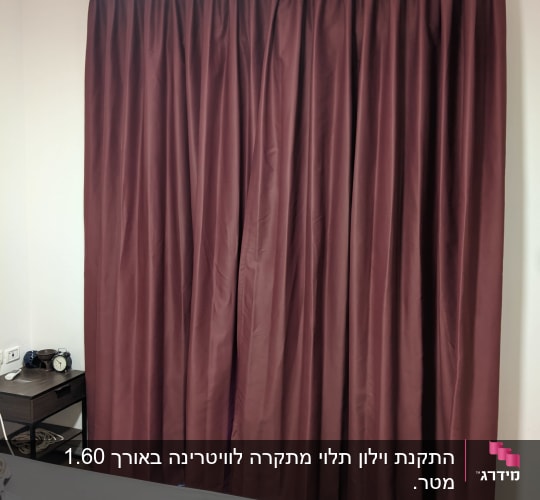 וילון ארוך בצבע בורדו תלוי על קיר לבן